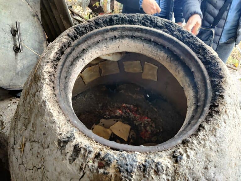 Cucina di pane tipico dell'Uzbekistan nel forno di argilla